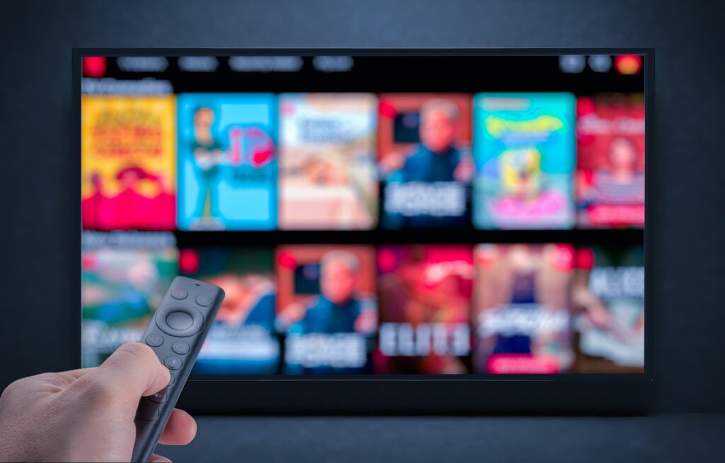 someone pointing a remote to a streaming service on their tv