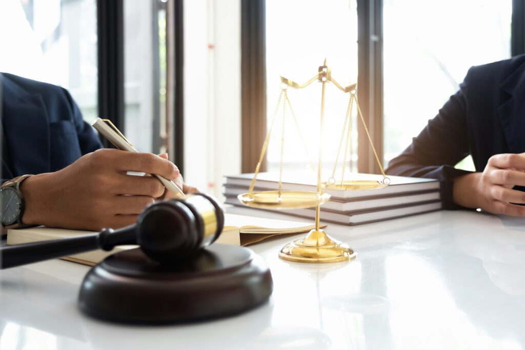 image showing legal items such as the scales of justice and a judges hammer.