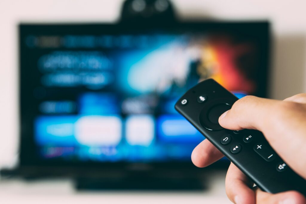 someone holding a remote control to a television